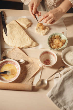 female hands knead the dough on a light background