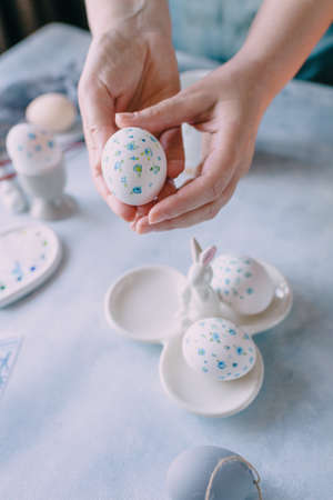 easter egg painted in blue flower in female handsの写真素材