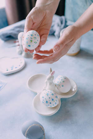 easter egg painted in blue flower in female handsの写真素材