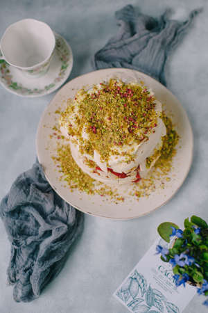 cake with protein cream sprinkled with pistachios on a light backgroundの写真素材