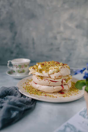 cake with protein cream sprinkled with pistachios on a light backgroundの写真素材