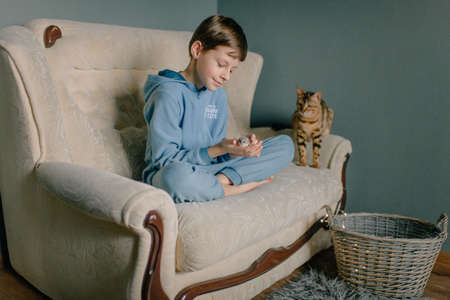 child boy in blue suit at home and his pets