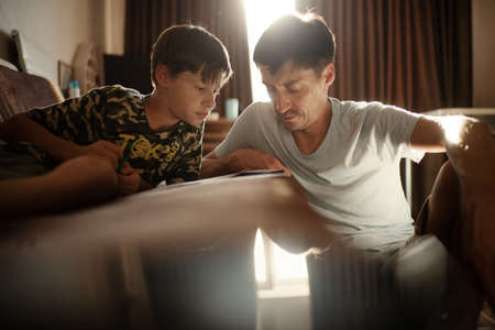 father and son study online while sitting in the room