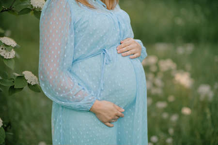 pregnant woman in a long dress holding her belly