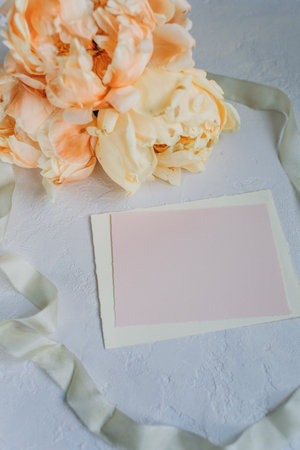 Postcard mockup on the background of peonies flowers on a light backgroundの写真素材