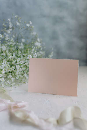 Postcard mockup on the background of peonies flowers on a light background