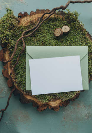 Envelope with blank greeting card on green moss background.の写真素材