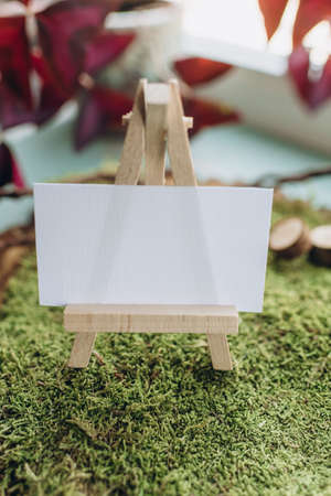 business card mockup in nature style, white paper on green moss and wood cutの写真素材