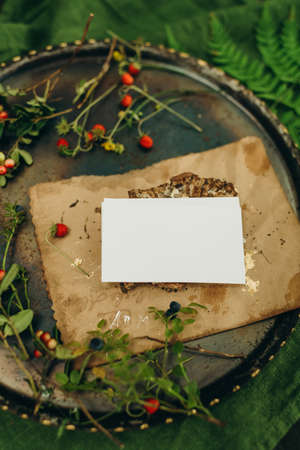 A rustic wedding table decorated with wildflowers, berries and a blank card.の写真素材