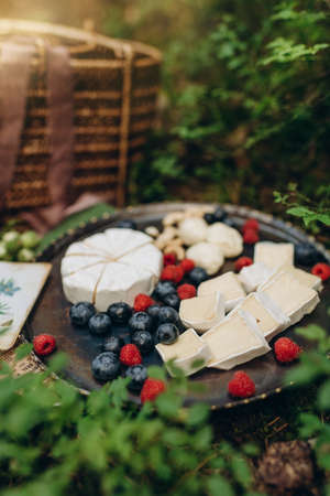 Cheese platter with brie, camembert, blueberries and raspberriesの写真素材