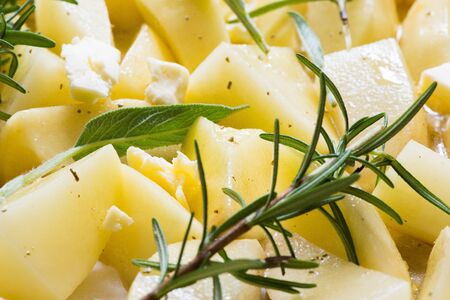 Roast potatoes to be cooked (ingredients - salt, rosemary, sage, oil, butter, spices)の写真素材