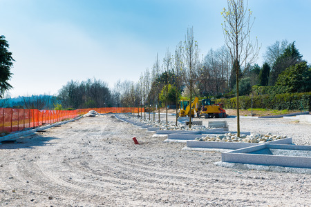 Construction of a car parking. Works for the realization and creation of new parking spaces separated by flower beds with treesの写真素材
