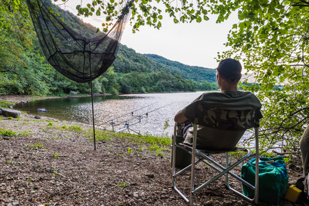 Fishing adventures. Fisherman waiting to catch a big fishの写真素材