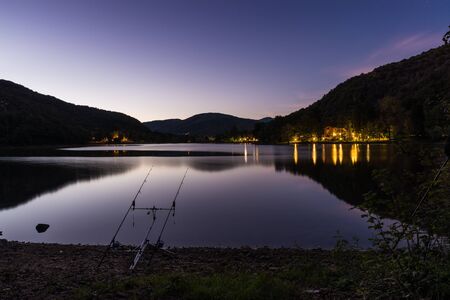 Night fishing adventures. Carp rods propped on a rod pod with two bite alarmsの写真素材