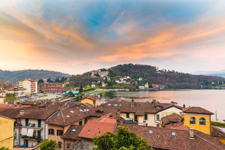 Lake Maggiore, Laveno, Italy. Picturesque sunrise. View towards the lake, the pier of the ferry, the railway station and part of the lake promenadeのeditorial素材