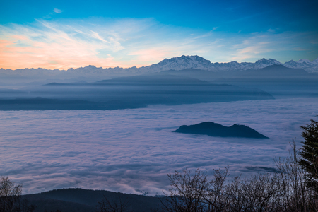 Alpine chain with Monte Rosa emerges from a sea of clouds at sunset. Aerial view from Campo dei Fiori of Varese, Italy. Winter high pressure and example of atmospheric stratificationの写真素材