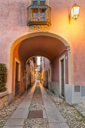 Beautiful scenic alley with historic and traditional houses and cobbled street. Picturesque Italian village, Orta San Giulio (street Giovanetti), on lake Orta, north Italyのeditorial素材