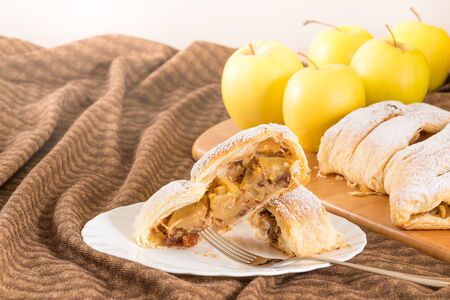 Slice of homemade apple strudel (apples pie) with puff pastry, cinnamon and raisinの写真素材