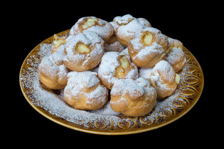 Cream puffs stuffed with custard isolated on black background. Selective focus, view from aboveの写真素材
