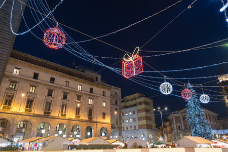 Colorful christmas lights at night and big Christmas tree at a christmas market. Varese city, square Monte Grappa, northern Italyの写真素材