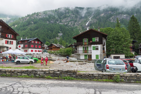 Overflowing of a torrent, flooding and landslides among the houses of a mountain village. Macugnaga village, Piedmont, Italy. Concept of climate change and natural disasterのeditorial素材