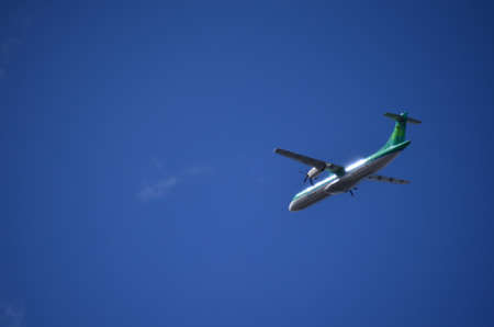 Green and White Double Helix Regional Airplane Flying Leftの写真素材
