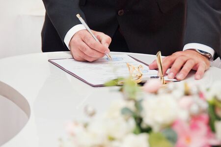 Newly-married couple signs documentsの写真素材