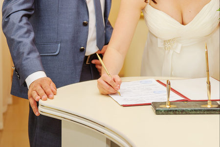 Bride signing marriage license or wedding contractの写真素材