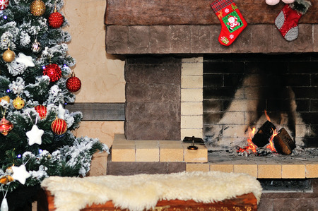 Fireplace with christmas tree and decorations in roomの写真素材