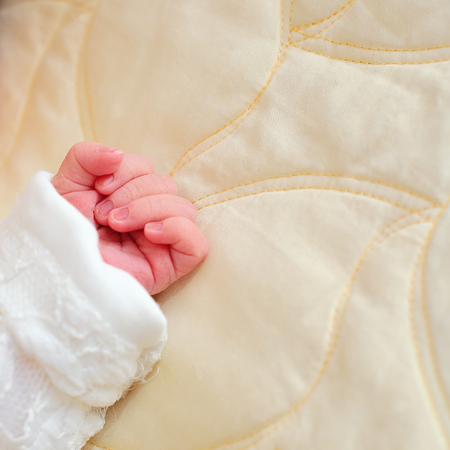 Tiny cute white baby hand close up
