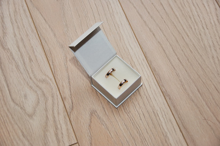 Close-up view of golden wedding rings on wooden tabletop