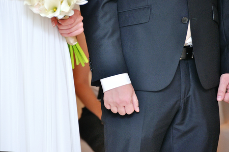 the groom and the bride hold each other by handsの写真素材