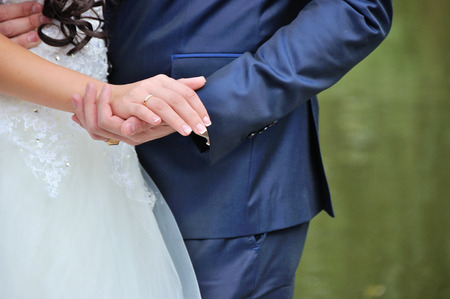 the groom and the bride hold each other by handsの写真素材