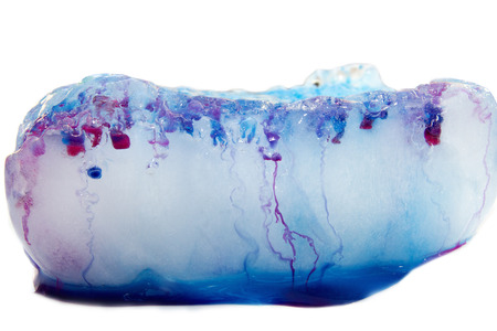 A piece of multicolored ice melted isolated on white background,