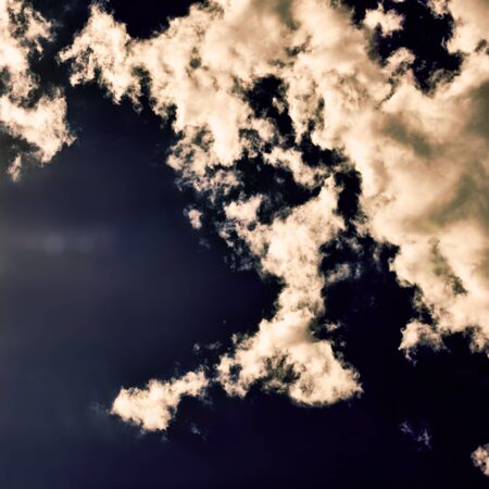 sun and cumulus white clouds against a beautiful blue sky, bizarre patternsの写真素材