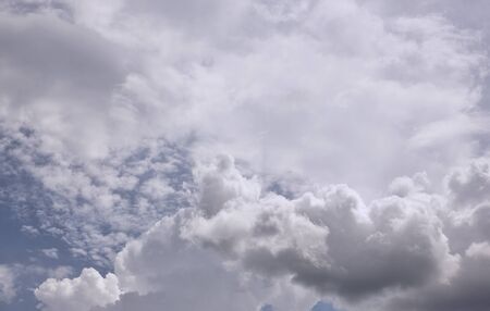 sun and cumulus white clouds against a beautiful blue sky, bizarre patternsの写真素材
