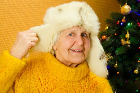 Positive senior female is expressing happiness in holiday. Portrait of happy grandmother over decorated New Year tree, merry Christmas concept, happy family, lifestyle indoor,の写真素材
