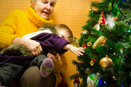 Portrait of happy grandmother hugging her granddaughter over Christmas presents and decorated New Year tree, merry Christmas concept, happy family, lifestyle indoor,の写真素材