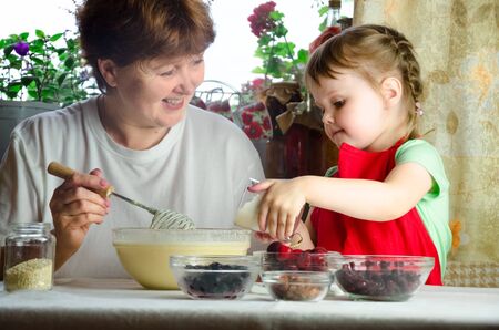 Portrait of faces, hands happy granny, granddaughter. toddler girl play with baking, dough, flour on kitchen. child baby try study cooking cookies, cake. Cozy family Look at each otherの写真素材