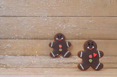 chocolate gingerbread cookies in the shape of men on a wooden board background