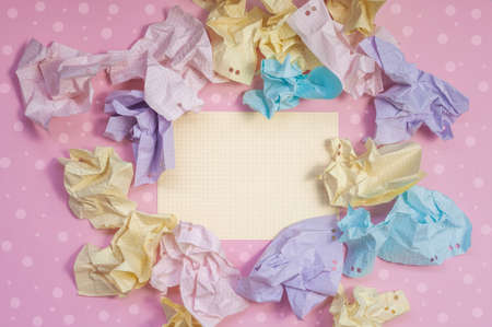 composition of crumpled paper in pink, yellow, blue and purple colors on a bright background.