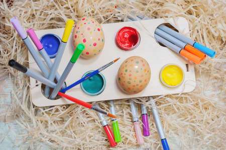 Easter composition of eggs on a background of hay. Children's creativity. Painting eggs