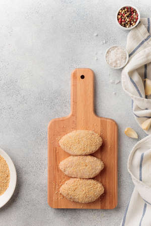 Raw braised meat cutlets on a wooden board top view