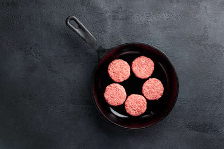 Meat cutlets in a pan, ready to fry top view