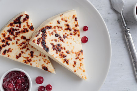Leipajuusto - traditional Finnish baked cheese - with red berries in a plateの写真素材