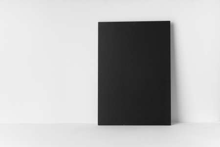 Empty chalk board and a sheet on a white tableの写真素材
