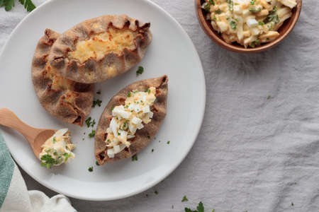 Traditional Finnish pastry - Karelian rye pie with rice porridge and an eggbutter on a tableの写真素材