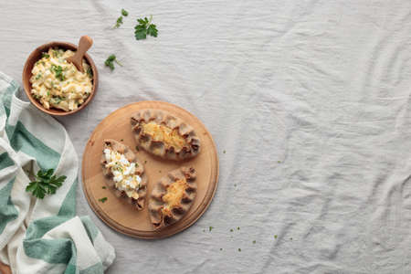 Traditional Finnish pastry - Karelian rye pie with rice porridge and an eggbutter on a tableの写真素材
