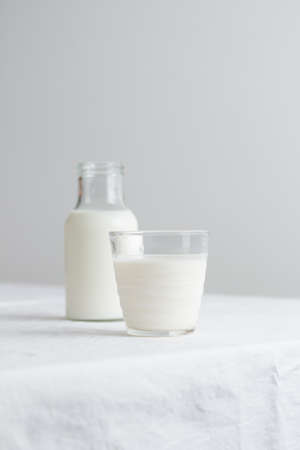 Fresh Milk on the table with white tablecloth and white wallの写真素材