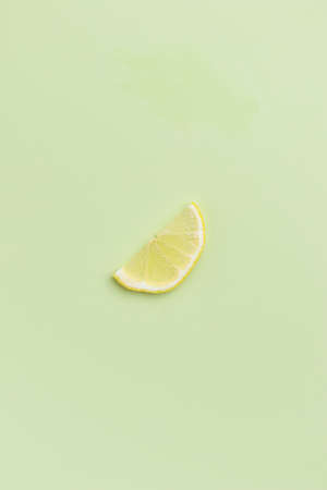 Lemon slice on a green background top viewの写真素材